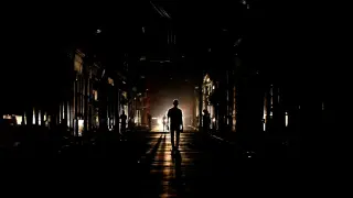 People walk on the street at night as Cuba is affected by an island-wide blackout, in Havana.