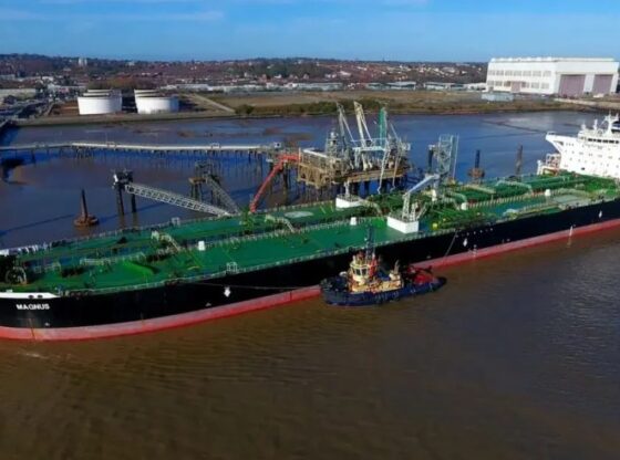 The oil tanker "Magnus" at a pier being assisted by a tugboat.