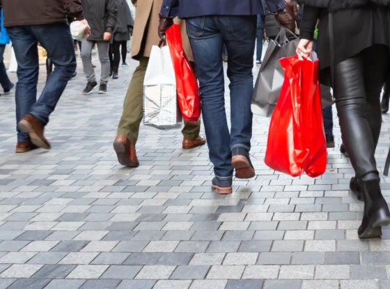 People with shopping bags walk through the pedestrian zone.