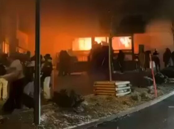 Building engulfed in flames, with smoke billowing out.