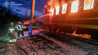 Firefighters try to put out the flames on the passenger train attacked by Russian drones in the Kharkiv region of Ukraine.