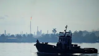 A boat passes in front of the Ñico López refinery in Havana Bay.