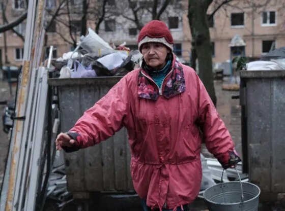 A resident of Kramatorsk empties the buckets she has filled with glass from her house, bombed by Russia on Sunday morning.
