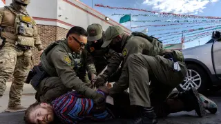 A protester holding an American flag is arrested by an ICE agent during a protest in Broadview, Illinois, on September 12.