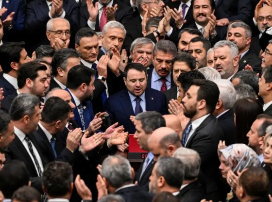Turkey's newly appointed Justice Minister Akin Gurlek surrounded by lawmakers from the ruling AKP, protecting him from Protestant deputies from the main opposition party.