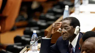 Mugabe, in a file photo, listening to Fidel Castro