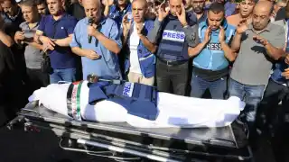 Family and friends pray over the body of Palestinian journalist Mohamed Abu Hatab on November 3.